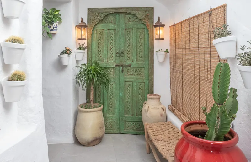 Entrada del restaurante El Patio con puerta verde tallada