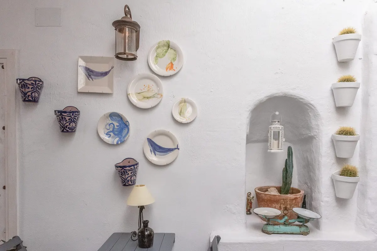 Pared decorada con platos artesanales y cerámica andaluza